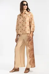 Camisa de manga larga color rosa con rayas verticales rojas y estampado de flores rojas. Con cuello camisero, puños elastizados y lazos regulables en los costados del ruedo.