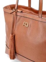 Cartera tipo shopper color marrón con textura perforada y colgante de borla.