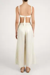 Pantalón fluido color crema, de corte ancho y relajado, con cintura elástica fruncida.