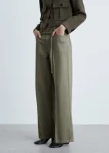 Pantalón estilo jeans de corte wide leg, color verde militar, con tiro medio, cierre frontal de cremallera y botón, cinco bolsillos y cinturón fino decorativo en la cintura.