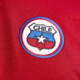 Camiseta de fútbol Adidas, reedición del modelo utilizado por la selección de Chile en 1994. Presenta un diseño en color rojo con cuello polo, detalles en blanco en la manga derecha y el número 10 estampado en el frente. Incluye el escudo de la selección y el logo de la marca.