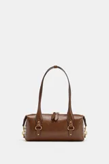 Bolso de hombro en color marrón con acabado efecto craquelado. Presenta un diseño rectangular con doble asa, cierre superior con cremallera y detalles metálicos dorados en la parte frontal y los laterales.