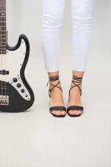 Sandalias negras de cuero con tacón cuadrado y tiras finas para atar al tobillo.