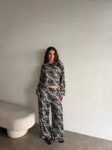 Remera manga larga de viscosa con estampado animal print tipo cebra en blanco y negro, corte holgado y cuello redondo. Presenta un pequeño parche cuadrado bordado en el pecho.