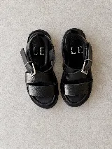 Sandalias de cuero marrón oscuro con efecto desgastado, tiras cruzadas en el empeine, hebilla metálica lateral y suela track negra con plataforma.