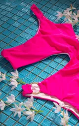 Traje de baño enterizo blanco con un solo hombro y aro dorado en la cadera.