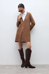 Sacón de punto color marrón, con cuello solapa, cierre frontal de dos botones dorados y dos bolsillos de parche en la parte delantera.