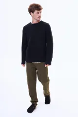 Pantalón de gabardina en color negro, de corte recto y ajuste cómodo, con cierre frontal y bolsillos laterales.