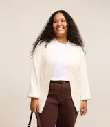 Cardigan largo de punto color crudo, con escote en V, manga larga ajustada y bolsillos delanteros.