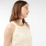 Top de croché color beige con diseño de tejido calado en patrón geométrico y escote halter.