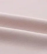 Blusa de crepé color rosa pálido, con cuello redondo, mangas cortas con volados, lazo en la cintura y botón en la espalda.