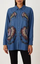 Camisa de jean azul con bordados de lentejuelas con forma de hojas.