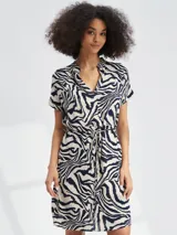 Vestido corto con estampado animal print tipo cebra en tonos blanco y negro. Presenta escote en V, mangas cortas y un lazo ajustable en la cintura para entallar la silueta.