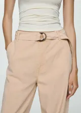Pantalon wideleg de tiro medio en color beige, confeccionado en mezcla de lyocell, lino y algodón. Cuenta con bolsillos laterales, trabillas para cinturón y un cinturón ajustable con hebilla circular.