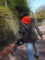 Blazer oversize bicolor de la marca Agnés, con diseño de doble faz que combina un lado en tejido gris oscuro liso y otro lado en tejido tostado con patrón de rayas diplomáticas. Cuenta con solapas clásicas, cierre frontal de dos botones y bolsillos aplicados.