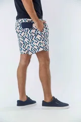 Short de baño azul marino con estampado de hojas de palmera color salmón.