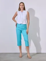 Pantalón capri de gabardina elastizada color celeste, con bolsillos simulados delanteros y bolsillos aplicados traseros. Tiene pretina ancha, corte recto y detalle calado en el ruedo.