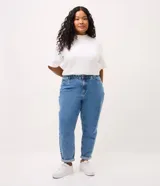 Pantalón mom jeans de tiro alto con lavado efecto mármol, corte holgado en cadera y piernas con ruedo ajustado. Cuenta con trabillas en la cintura, bolsillos funcionales y cierre frontal con botón.