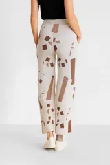 Pantalon de tejido jacquard con corte ancho y tiro alto, presenta un diseño geométrico abstracto en tonos verdes, celestes y blancos.