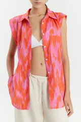 Camisa sin mangas de voile de algodón con estampado abstracto en tonos rosados y anaranjados. Tiene cuello camisero, cartera con botones a la vista, tajos laterales y bolsillo de parche en el delantero.