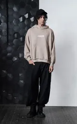 Hoodie oversize color gris topo, confeccionado en rústico de algodón, con capucha forrada, bolsillo canguro y costuras expuestas en mangas y ruedo. Presenta estampa gráfica en la espalda con la palabra AMOR y diversos motivos románticos.
