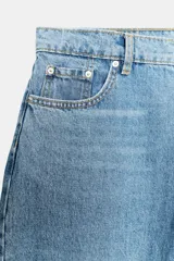 Jeans capri balloon leg de tiro medio en color celeste, con trabillas para cinto, bolsillos delanteros y traseros, y cierre frontal con botón y cremallera.