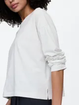 Remera de manga larga color salmón, con cuello redondo y corte holgado.