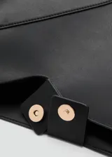 Bolso tipo shopper de diseño minimalista en color negro, con estructura geométrica y costuras decorativas en forma de V. Cuenta con una asa superior fija y un compartimento principal amplio.