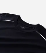 Remera de algodón color blanco, con cuello redondo, manga corta y detalle de raya negra contrastante que recorre la parte superior de los hombros y mangas. Diseño de corte holgado.