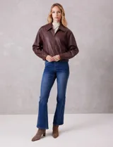 Campera de eco cuero color bordó, con cuello camisero, cierre frontal metálico y bolsillos laterales. Presenta un diseño de corte recto y forro interno a tono.