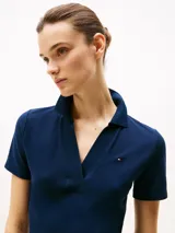 Vestido azul marino tipo chomba de algodón elástico, corte slim, largo hasta la rodilla, cuello en V y mangas cortas.