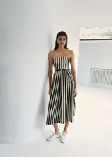 Vestido midi de corte evasé con diseño de rayas verticales en blanco y negro, escote palabra de honor y detalle de cinturón fino en la cintura.