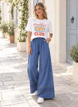 Palazzo de denim celeste claro, de corte wide leg, con cintura elástica y detalle de bordado decorativo en el ruedo.