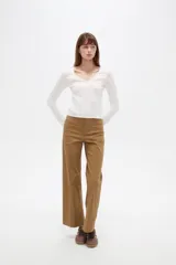 Remera negra de manga larga y calce al cuerpo, confeccionada en poliéster con diseño calado y escote en V.