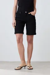 Bermuda de jean color blanco, con cinco bolsillos, corte a la rodilla y cierre frontal con botón y cremallera.