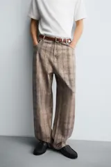 Jeans de corte holgado y amplio en toda la pierna, tiro medio. Tejido rígido con estampado a cuadros con efecto lavado. Cuenta con cinco bolsillos y cierre frontal con cremallera y botón.