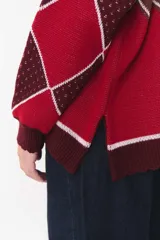 Buzo de tejido de punto con diseño geométrico y combinación de colores en contraste. Presenta cuello redondo, mangas largas y corte oversized.