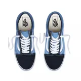 Championes Vans modelo Old Skool, con diseño clásico de caña baja. Presentan una combinación de paneles de lona azul y refuerzos de gamuza en puntera y talón, con la icónica banda lateral blanca y suela de goma vulcanizada.