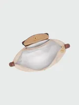 Mochila de diseño minimalista en color beige, con solapa y asa superior en cuero marrón texturizado. Cuenta con correas ajustables en color marrón y cierre principal.
