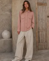 Camisa de lana merino color rosado viejo, de corte recto con bolsillos frontales con solapa y cierre de botones.