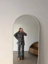 Buzo de cuello redondo y mangas largas con diseño holgado, confeccionado en tela de viscosa con textura acanalada y estampado animal print de leopardo.
