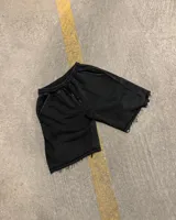 Short de algodón con efecto desgastado, corte baggy holgado, cintura elástica con cordón ajustable y bordes deshilachados.