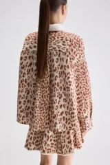 Sobrecamisa de calce relajado y estampado animal print con diseño de leopardo. Cuenta con cuello camisero en color blanco de textura acanalada, cierre frontal de botones a presión, mangas largas y bolsillos frontales aplicados.