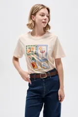 Remera de algodón color beige con cuello redondo y diseño holgado, con estampado frontal de ilustraciones estilo postal con bebidas y frutas.
