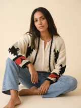 Cardigan crudo de tejido de punto con motivos navajo en rojo, negro y verde claro, sin botones y mangas largas.