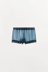 Shorts de tiro alto confeccionados en mezcla de viscosa, en color azul con detalles de encaje negro en contraste en la cintura y el ruedo.