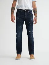 Jean de calce slim fit, color azul oscuro con detalles de desgaste y roturas.