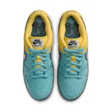 Championes Nike SB Dunk Low Pro con paneles delanteros de gamuza turquesa y parte trasera de cuero liso amarillo, con swoosh holográfico brillante y suela gris.