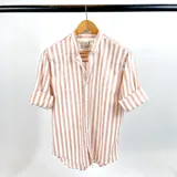 Camisa de lino a rayas verticales color tierra y blanco, con cuello mao y mangas largas con puños abotonados.