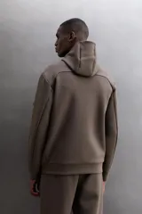 Campera canguro de Zara Athleticz, modelo relaxed fit, confeccionada en tejido técnico compacto elástico con mezcla de algodón en color azul marino. Cuenta con cuello subido con capucha, manga larga con bolsillo lateral con cierre, bolsillos frontales con cierre y acabado termofijado, cierre frontal de doble dirección y logo estampado en el bajo.